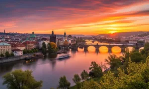 Vista panorâmica de Praga ao pôr do sol com as pontes iluminadas refletindo no rio